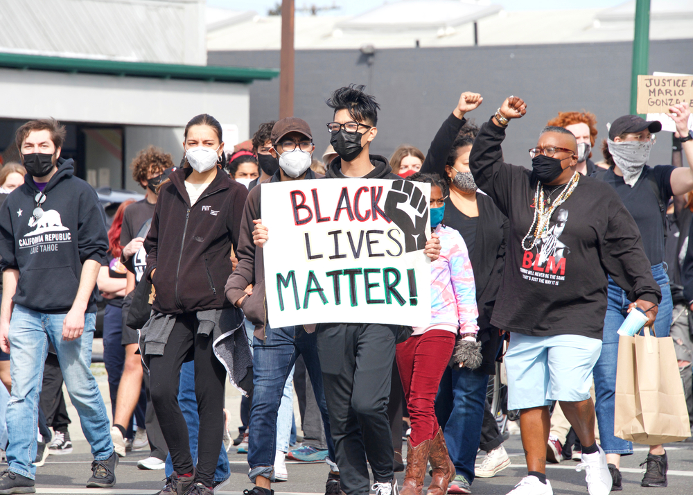 Alameda, CA - Apr 24, 2021: Unidentified participants holding signs at a youth lead End Police Brutality March marching from Washington Park to Alameda Police Station for a rally.